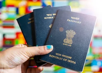 Indian expatriates submitting passport and visa application documents at an outsourcing service center in the UAE.