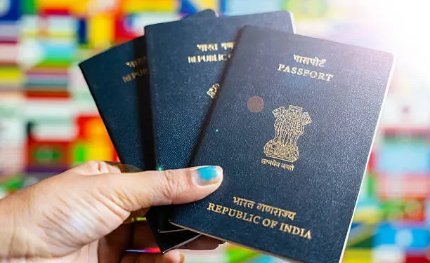 Indian expatriates submitting passport and visa application documents at an outsourcing service center in the UAE.