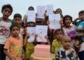 Underprivileged children in Delhi holding a birthday banner for His Highness Sheikh Mohammed bin Rashid Al Maktoum during a food distribution drive.