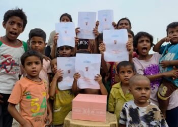 Underprivileged children in Delhi holding a birthday banner for His Highness Sheikh Mohammed bin Rashid Al Maktoum during a food distribution drive.
