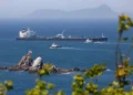 Commercial oil tanker transiting through the Strait of Hormuz under maritime surveillance.