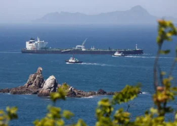 Commercial oil tanker transiting through the Strait of Hormuz under maritime surveillance.