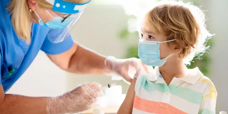 Healthcare professional administering routine vaccination to a primary school student in the UAE