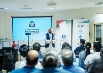 Abu Dhabi Civil Defence officers instructing industrial workers on hazardous materials handling and safety equipment.