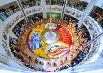 Healthcare workers at Burjeel Medical City standing around a 250-square-meter floral carpet featuring UAE President Sheikh Mohamed bin Zayed Al Nahyan.