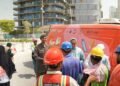 GDRFA officers distributing cold drinking water and refreshments to outdoor workers in Dubai during summer.