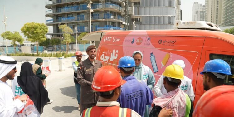GDRFA officers distributing cold drinking water and refreshments to outdoor workers in Dubai during summer.
