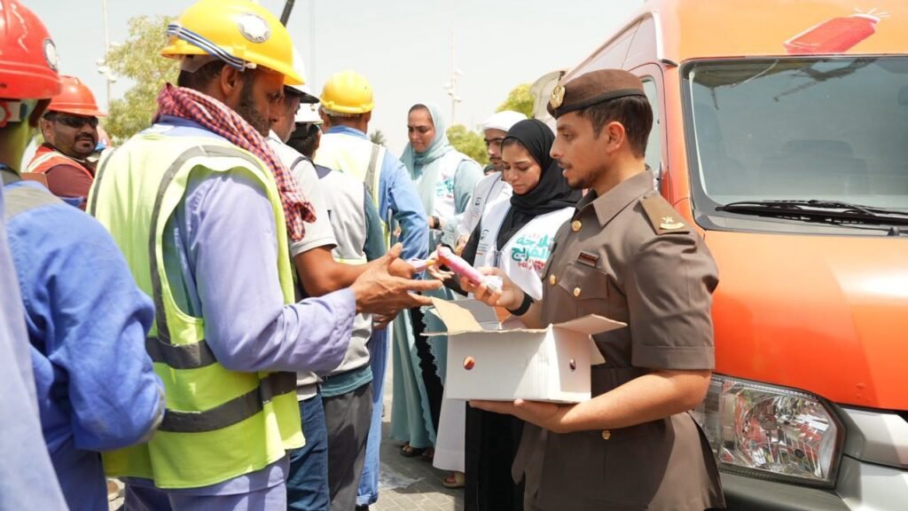 GDRFA officers distributing cold drinking water and refreshments to outdoor workers in Dubai during summer.