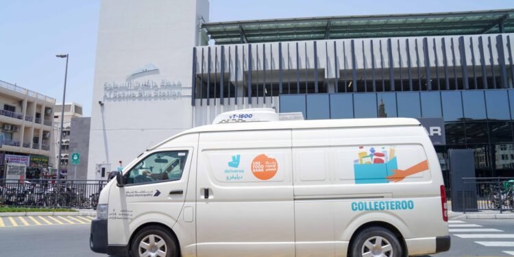 Delivery riders receiving meals at a Dubai metro station rest area during the summer midday break.