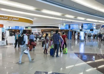 Passengers waiting at Dubai International Airport terminal amid flight cancellations and delays