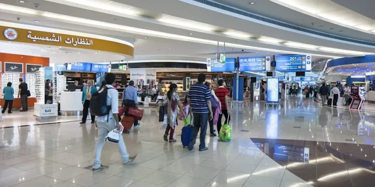 Passengers waiting at Dubai International Airport terminal amid flight cancellations and delays